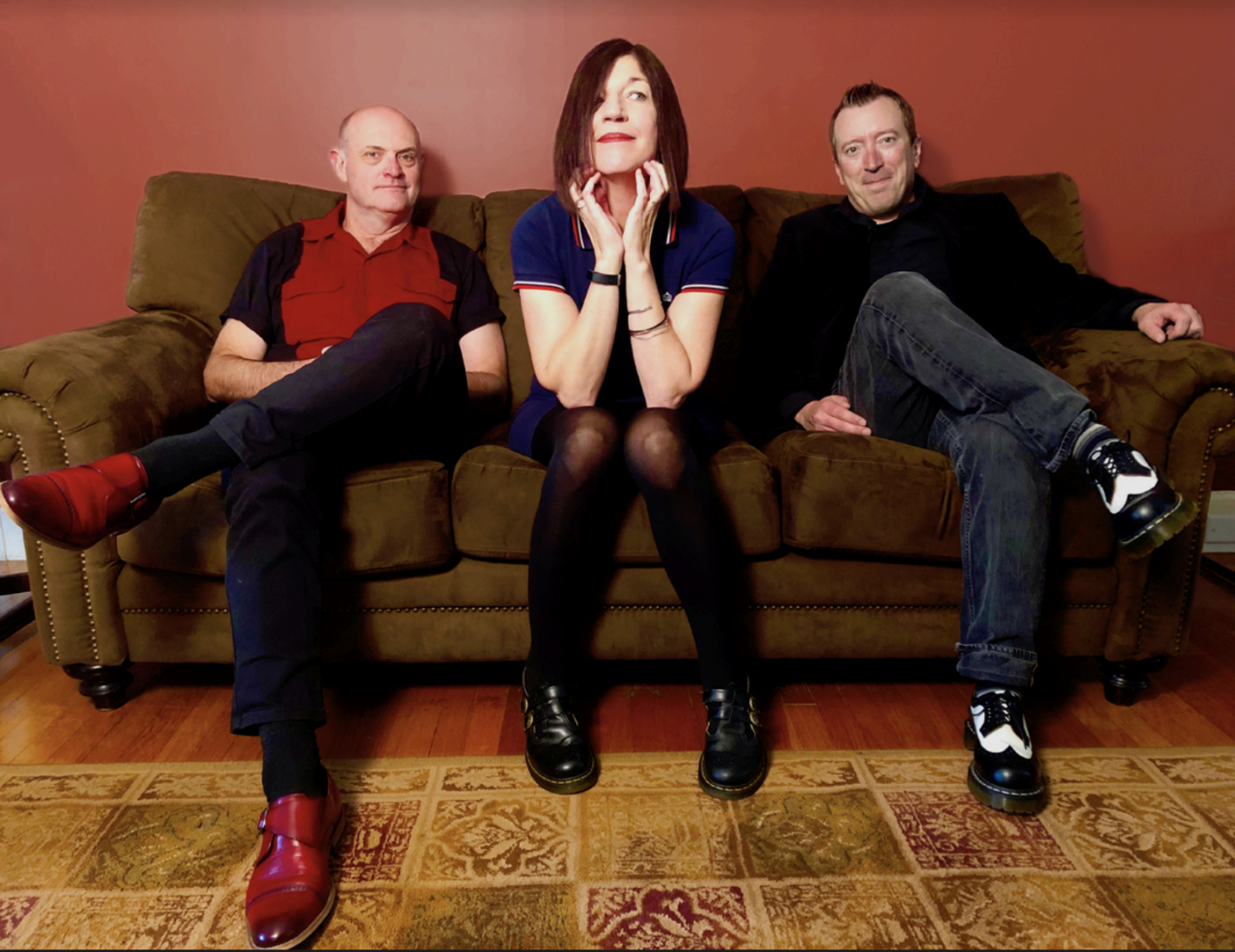   [From left to right]  Tim Gillis, Linda Pardee and Ron Belanger of The Chelsea Curve sit side by side on a brown couch. Photo courtesy of The Chelsea Curve 