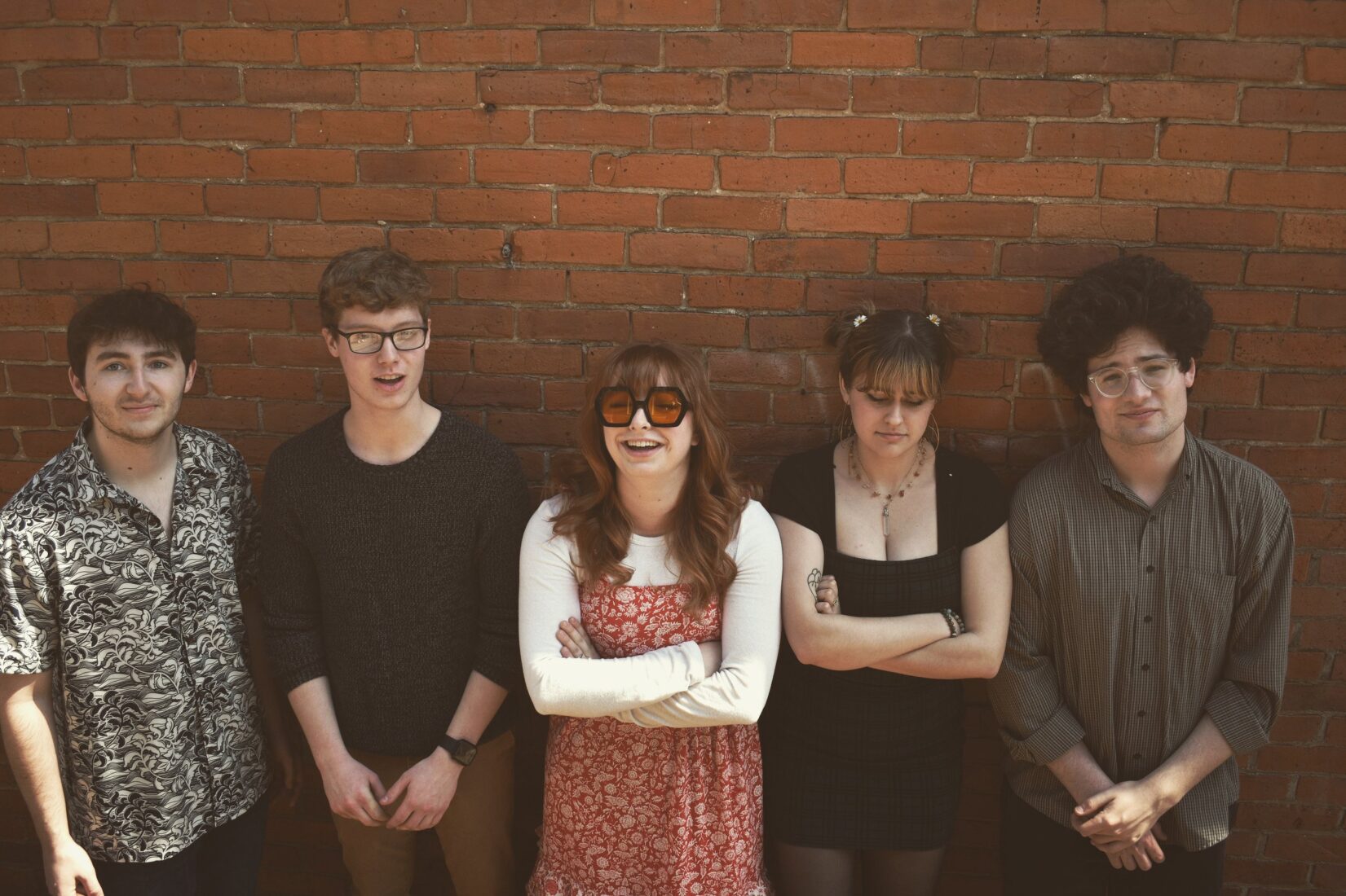 From left to right: Torncello, Travison, Sandt, McQueeny, and Aaron pose casually against a brick wall. Photo courtesy of Becca Torncello