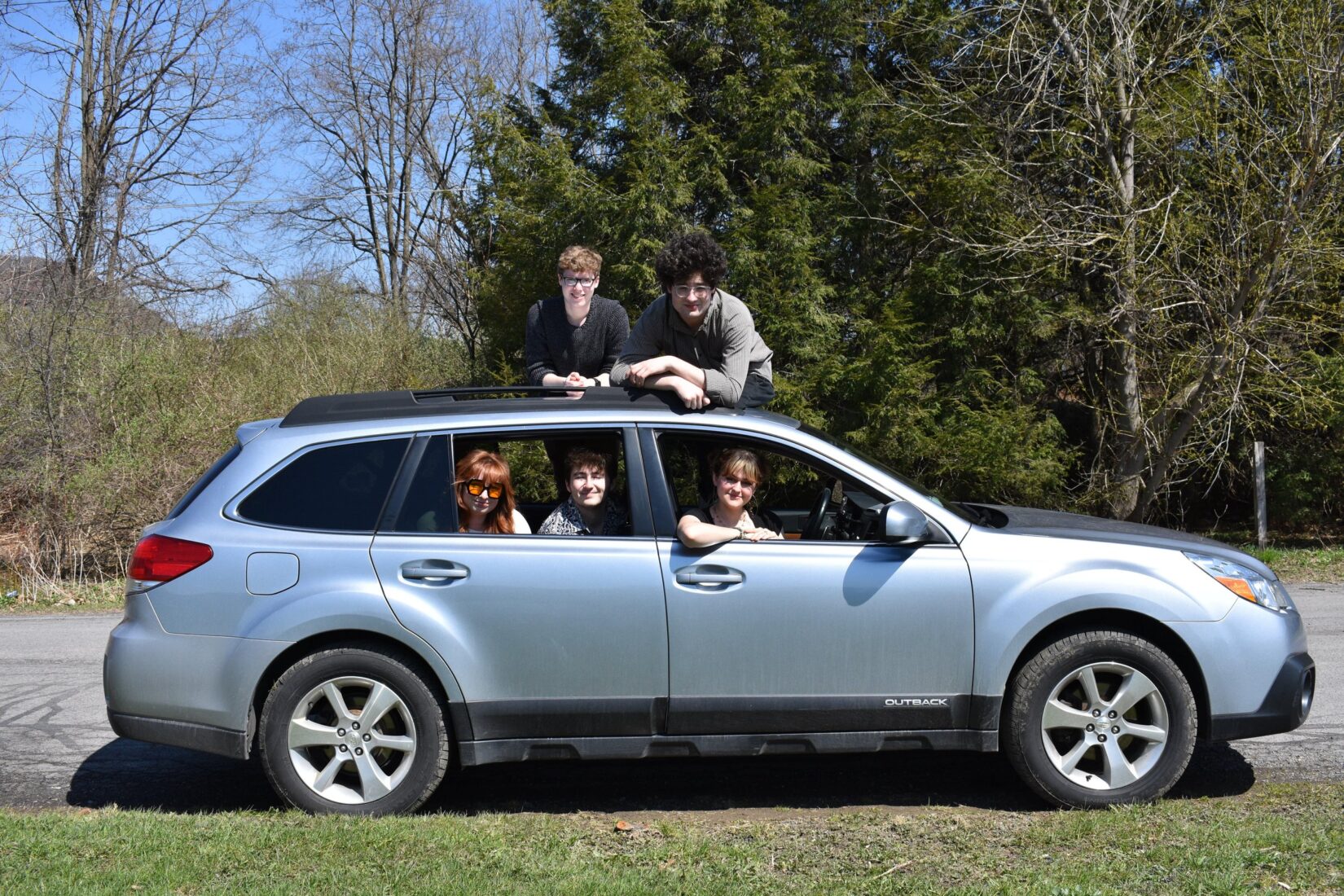From top to bottom: Travison, Aaron, Sandt, Torncello, and McQueeny smile from the side of a Subaru. Photo courtesy of Becca Torncello